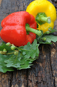 烹饪两只黄色的甜辣椒和两只红色的放在木制顶楼上食物绿色图片