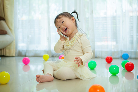 坐在地板上听电话的可爱小孩图片