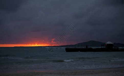 超过在加拉帕戈斯群岛埃乔托尔当光线照倒在地平上时一个对着地平线的码头有一个火辣的紫红和橙色日落波多黎各厄瓜尔图片