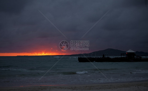 超过在加拉帕戈斯群岛埃乔托尔当光线照倒在地平上时一个对着地平线的码头有一个火辣的紫红和橙色日落波多黎各厄瓜尔图片