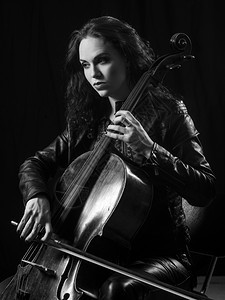 一位美丽的女音乐家演奏大提琴的照片黑色坐着玩图片