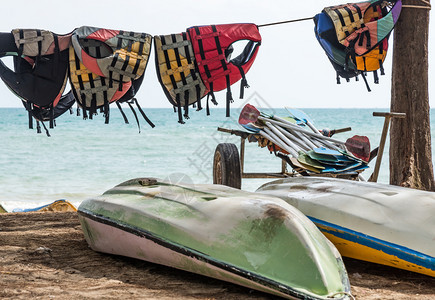 救援节省桩旧生衣挂在皮艇和海边的划桨堆旁图片