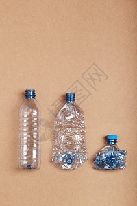 概念的压扁空塑料瓶排成一放在纸板背景上收集塑料废物以回收污染和过多废物的概念复制文本空间节省垃圾图片