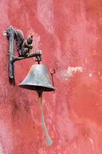 古董建筑学红色墙上挂着雕像松鼠的警铃铁图片