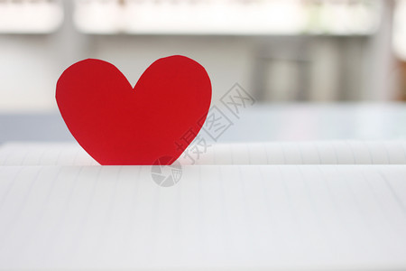 床单天覆盖红心被放在一本空书上用于在爱的概念和情人节设计图片