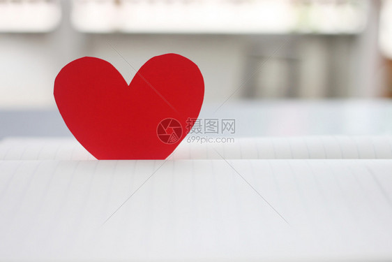 床单天覆盖红心被放在一本空书上用于在爱的概念和情人节设计图片