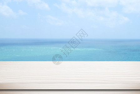 假期自然模糊海面和蓝天空背景模板产品显示时的空白木桌超过图片