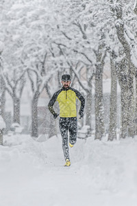 在寒冷的冬天雪中奔跑带着胡子火车的男人积极耐力霜图片