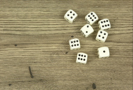 七张白骰子散布在旧式风格的木制柜台上水平视图风险乐趣数字背景图片