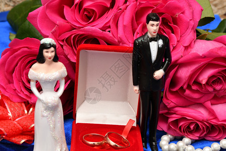 庆典美丽的礼物结婚戒指和一束粉红玫瑰花图片