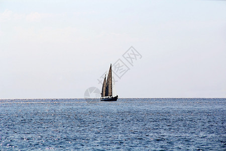 船首斜桅疏松航行海景以平静的水和阳光中帆船图片