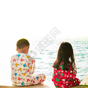 在海边坐着玩耍的两个孩子图片