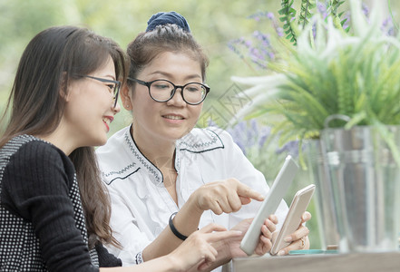 幸福社会的眼镜手拿着机的亚洲女人用放松的情绪说话图片