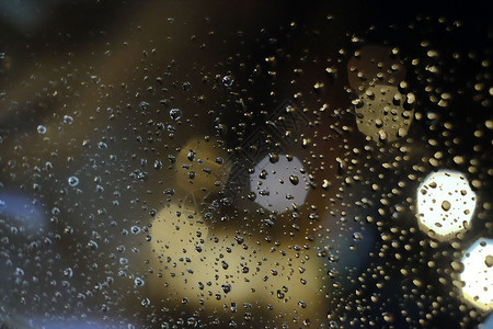 暴风雨滴流动天气雨在窗户上落下抽象的灯光模糊了背景背景图片