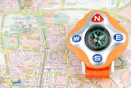 城市旅行概念上的橙色罗盘磁铁目的地形图片