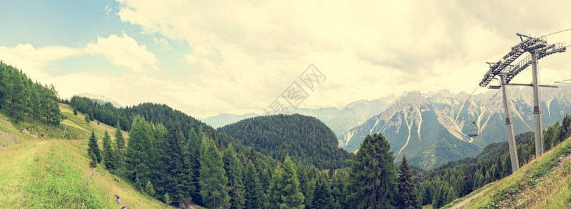 运动美丽的意大利带有森林多洛米特人山谷和夏季吊椅的山地全景天空与云状星具有古老效果的图片过滤器图片