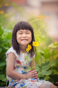 可爱的自然女孩肖像与黄色宇宙花束在手牙般微笑的脸松弛图片