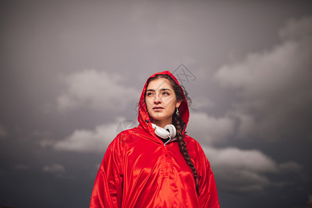 女孩年轻子在雨天与衣和耳机一起站在田地上户外秋天图片