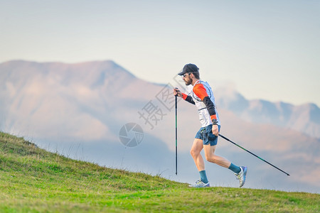 锻炼身体的Athlete练习北欧在山地草原上行走全景图片