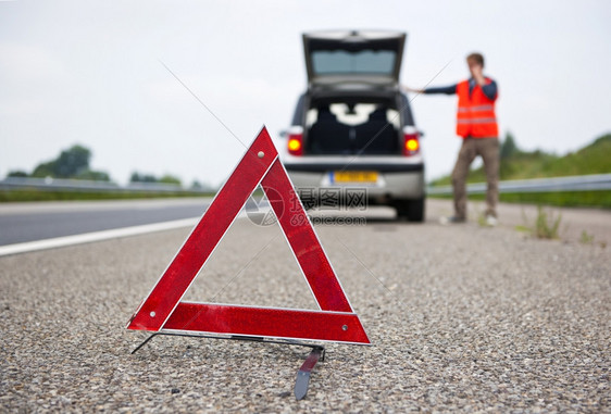 警示在一辆撞坏的汽车后面牌司机呼救注意三角形上重点一种路图片
