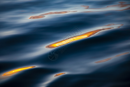 自然波在深水中以金色和黄反映光亮海浪有色束图片