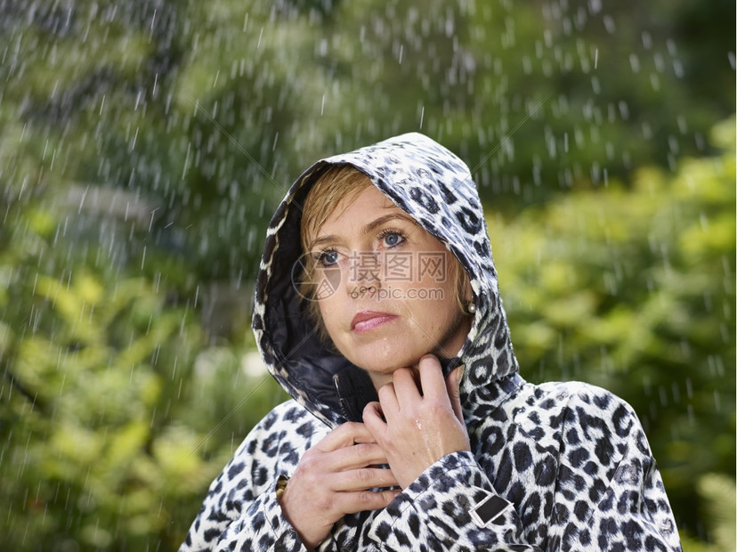 夏天身穿雨衣季夏日背景绿色自然的成熟女人天气图片