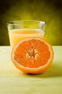 斑点喝木制桌上的玻璃杯里新鲜橙子汁果图片