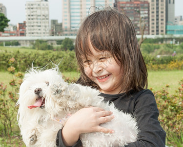 在公园抱狗的可爱年轻女孩经过泰国动物图片