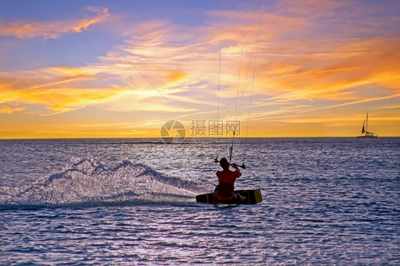 热带自然日落时在加勒比海阿鲁巴岛的棕榈海滩Kite冲浪行动图片