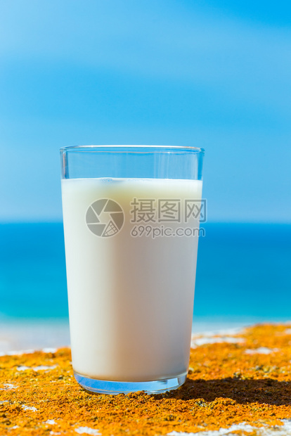 玻璃杯装满奶蓝海和天空口渴新鲜的饮料图片