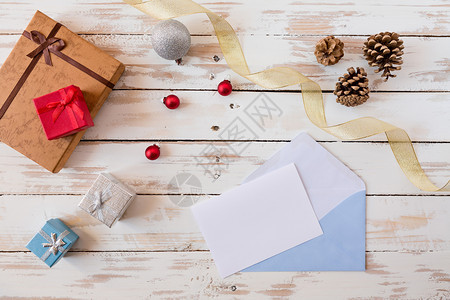 假期圣诞信上面写着礼物装饰品和松果仁的木桌圣诞信上面写着玫瑰木桌子白色的冬天图片