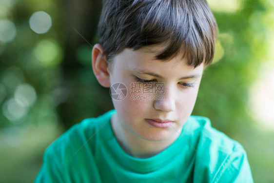 人们近距离接不快乐男孩坐在花园外的门郁闷水平图片
