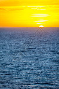 温和的多云阳光海面上日落平线直和温柔的海洋波浪图片