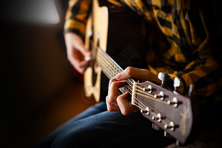 岩石玩音乐吉他近距离摄影机的青年男声学吉他游戏女手图片