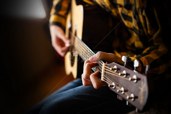 岩石玩音乐吉他近距离摄影机的青年男声学吉他游戏女手图片