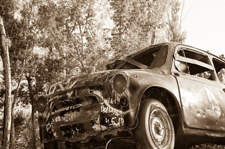 在森林里孤单的老旧生锈汽车的古董腐蚀图片