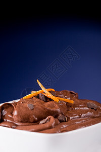 美味的巧克力慕斯在一个有橙色芝士的白碗里奶油面糖图片