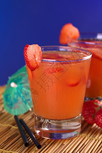 草莓汁热情饮料秘鲁鸡尾酒叫做Pisquina由辣椒激情果子和红莓汁新鲜草糖和冰选择焦点关注玻璃前边缘和圆草莓片的前面注皮斯奎纳背景