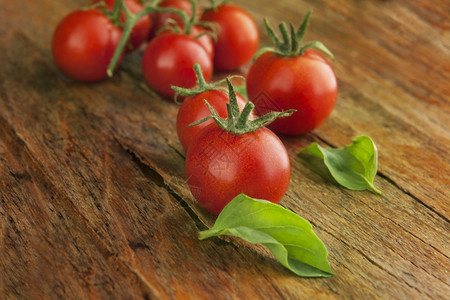 红色的成熟明亮樱桃西红柿在天然光照的木表面图片