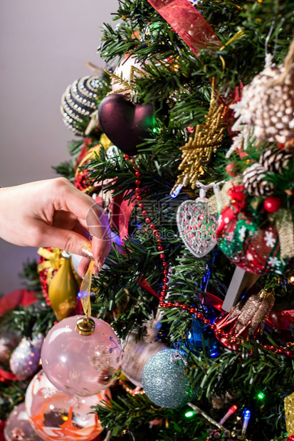 将圣诞装饰品挂在圣诞树上图片