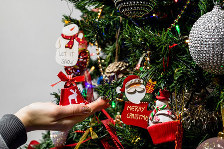 将圣诞装饰品挂在圣诞树上图片