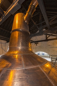 一种爱尔兰铜锅仍然用于生产爱尔兰威士忌A它是一种用来通过加热有选择地沸煮和冷却以凝结蒸气来发酵的谷物泥浆机器行业仪经过背景图片