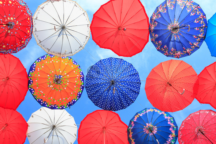 丰富多彩的节日蓝天上有许多色彩的雨伞天空图片