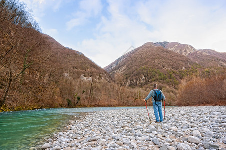 远足登山者在一条河流的岸上向着朗布勒山走去大约60岁潮地漫步者图片