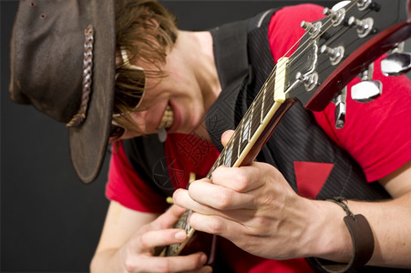 一个时髦的吉他手在重独奏曲中选择关注左手音乐家一种岩石太阳镜图片