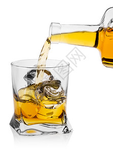 橙玻璃杯烧加冰威士忌酒瓶从白底孤立的子中倒出威士忌玻璃杯烧加酒装冰倒出威士忌琥珀色饮料图片