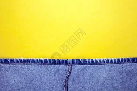 帆布蓝牛仔裤有黄针和色背景纤维棉布图片