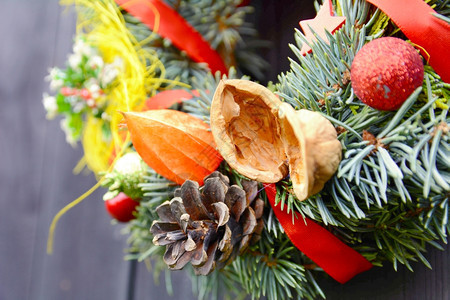 装饰圣诞节手工制作装饰花圈配有小装饰品和木本底红丝带假期手工制作的图片