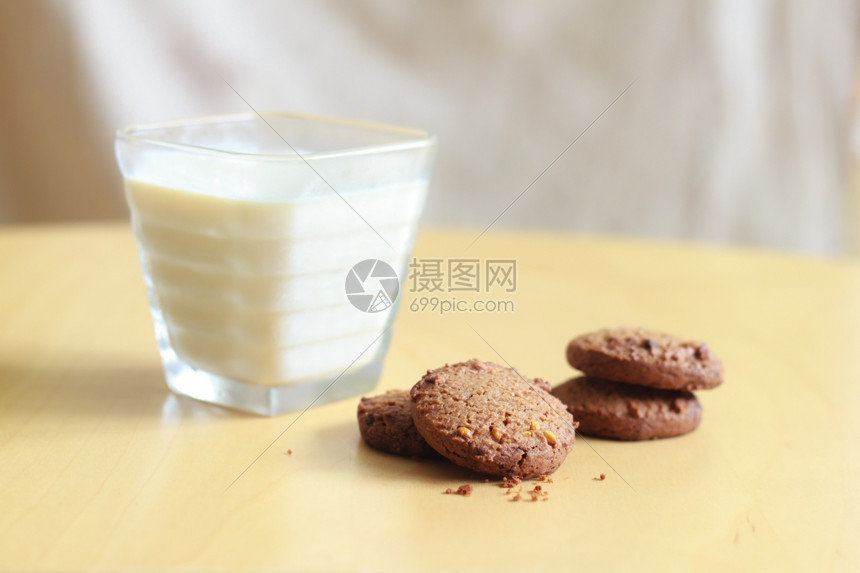 巧克力薯片饼干和木制桌上的牛奶杯曲奇饼芯片食物图片