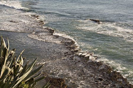 力量在葡萄牙低潮时冲过岩石的波浪潮狂怒图片